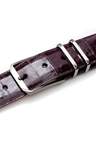 Burgundy crocodile skin belt with a sleek satin nickel buckle and refined stitching.