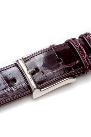 Burgundy alligator skin belt with a polished silver buckle and stitched leather edges.